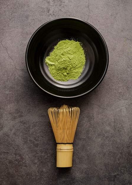 Vue de dessus de la poudre de thé matcha dans un bol avec un fouet en bambou