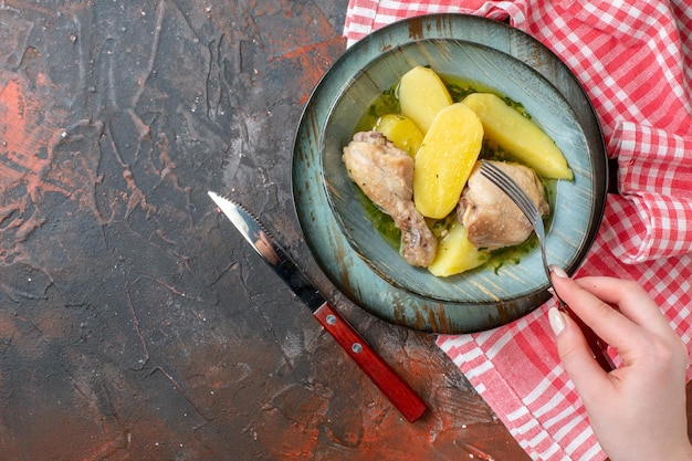 Vue de dessus poulet bouilli avec pommes de terre cuites à l'intérieur de la plaque sur fond sombre couleur sauce alimentaire viande photo calories dîner huile