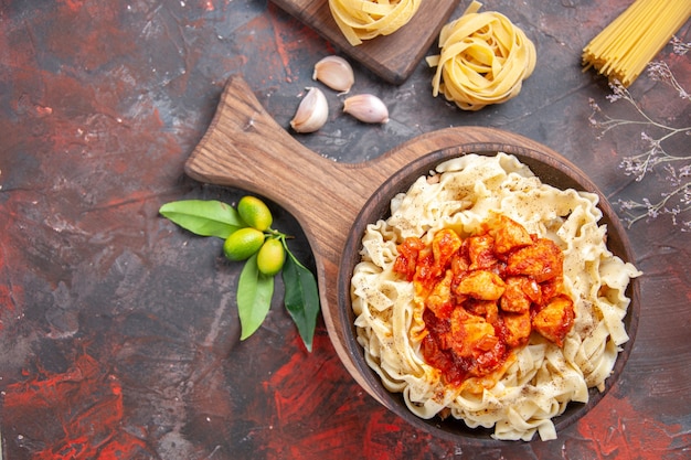 Vue de dessus poulet avec plat de pâtes de pâte sur fond sombre plat de pâte de pâtes de surface sombre