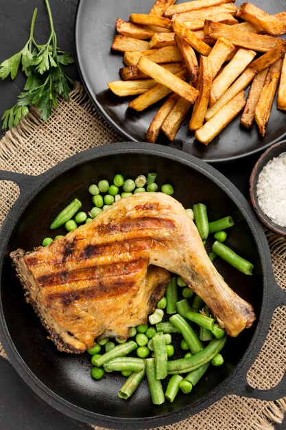 Vue de dessus de poulet et de pois cuits au four dans une casserole avec des pommes de terre