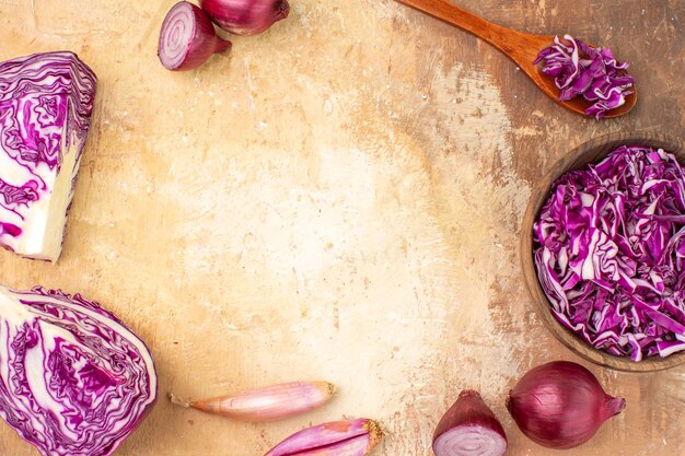 Vue de dessus préparation d'oignons rouges et de chou pour une salade de betteraves rouges maison sur un fond en bois avec espace de copie