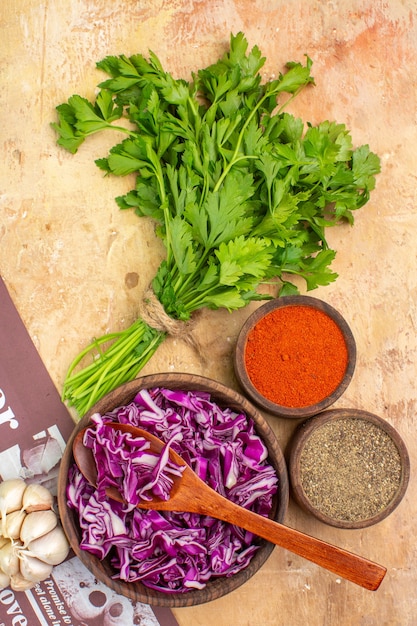 Photo gratuite vue de dessus préparez un bouquet d'ail de persil avec un bol de poivre noir curcuma poivre moulu chou rouge haché pour salade sur une table en bois