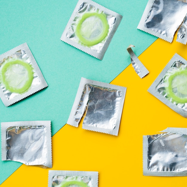 Vue de dessus des préservatifs sur fond vert et jaune