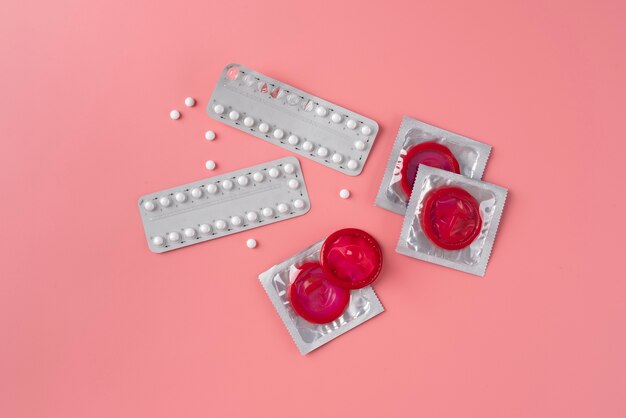 Vue de dessus des préservatifs et des pilules rouges