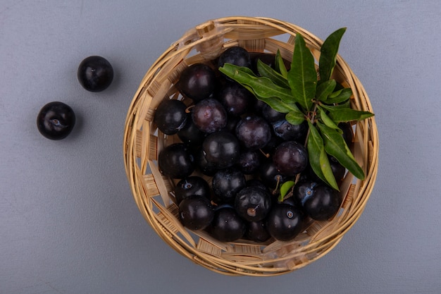 Vue de dessus prune cerise dans un panier sur fond gris