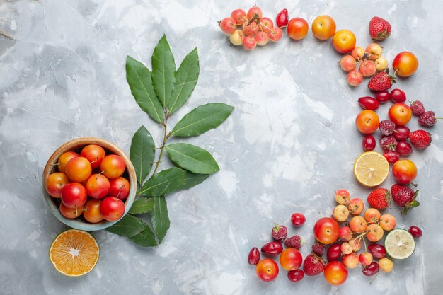 Vue de dessus prunes griottes au citron et autres fruits sur le bureau léger