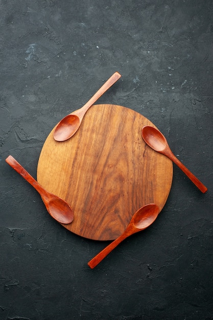 Vue de dessus quatre cuillères à bord rond sur table sombre