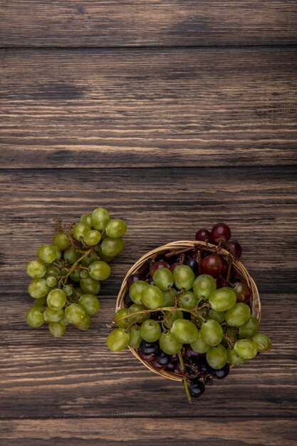 Vue de dessus des raisins dans le panier et sur fond de bois avec espace copie