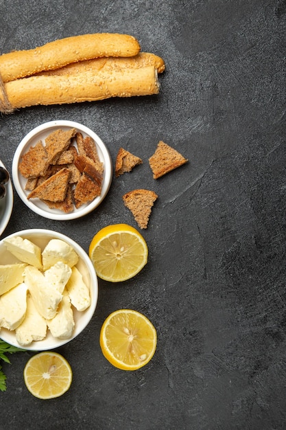 Vue de dessus des raisins frais avec des feuilles de fromage et des tranches de citron sur une surface sombre, un plat de petit-déjeuner, des fruits au lait