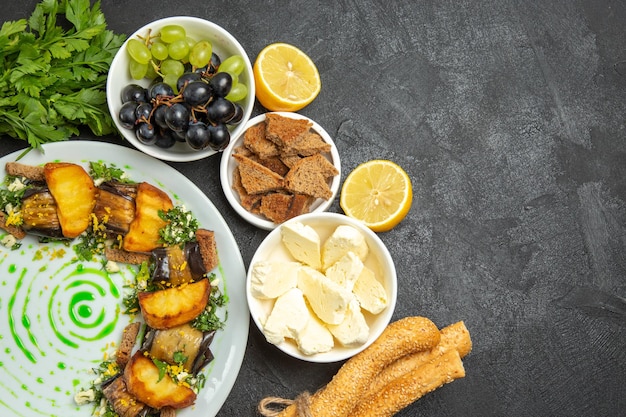 Vue de dessus des raisins frais et moelleux avec du fromage blanc et du pain tranché sur une surface sombre repas alimentaire fruits au lait