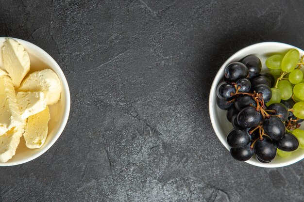 Vue de dessus des raisins frais et moelleux avec du fromage blanc sur une surface sombre repas alimentaire lait fruit