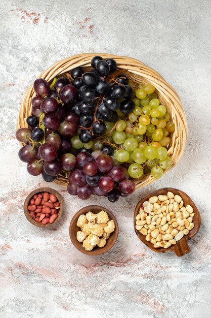 Vue de dessus des raisins frais avec des noix sur une surface blanche