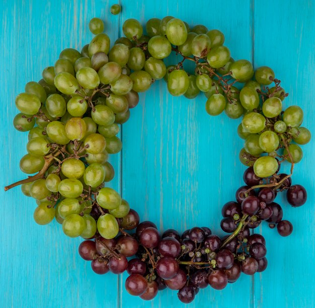 Vue de dessus des raisins mis en forme ronde sur fond bleu avec espace copie