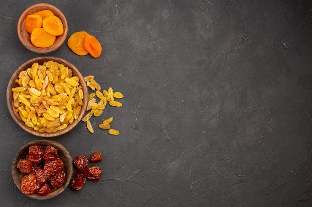 Vue De Dessus Des Raisins Secs Avec Abricots Secs à L'intérieur De Petits Pots Sur Surface Grise