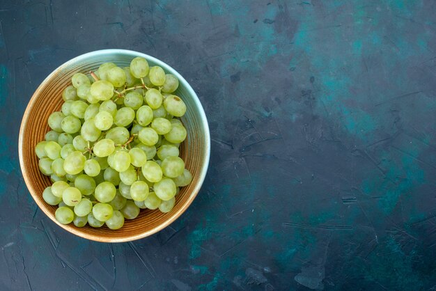 Vue de dessus des raisins verts frais sur bleu foncé