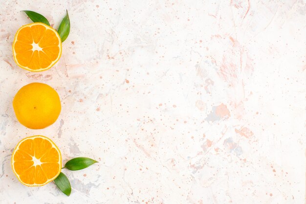 Vue de dessus de la rangée verticale de mandarines fraîches sur une surface isolée lumineuse avec un espace libre