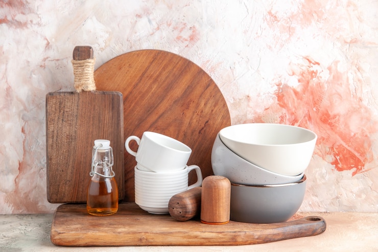 Photo gratuit vue de dessus de la râpe à pots empilés de bouteilles d'huile sur une planche à découper en bois sur une surface colorée