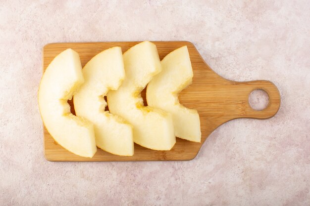 Une vue de dessus reconstitué melon frais moelleux juteux et doux doublé sur un bureau en bois