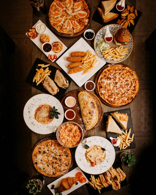 Vue de dessus des repas délicieux délicieux pâtisseries et plats différents sur la surface brune