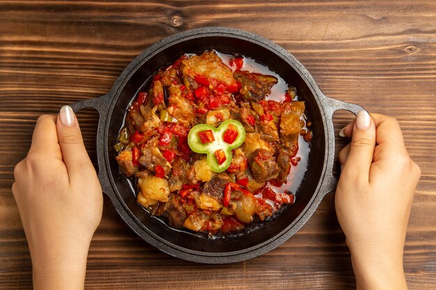 Vue de dessus repas de légumes cuits à l'intérieur de la casserole sur le bureau brun