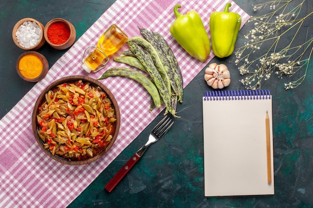 Vue de dessus repas de légumes en tranches avec assaisonnements sur bureau bleu