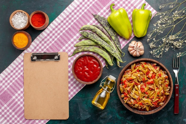 Vue de dessus repas de légumes en tranches cuit délicieux plat sur bureau bleu