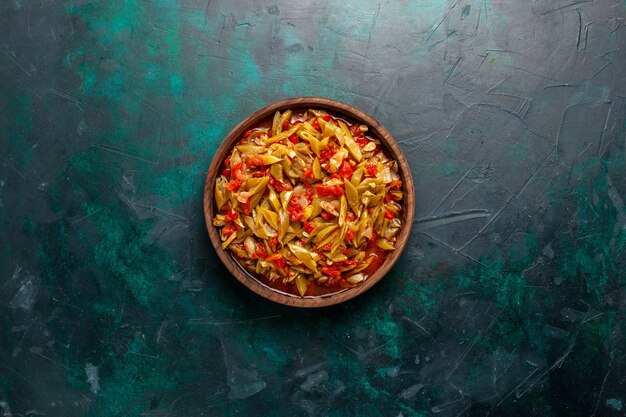 Vue de dessus repas de légumes en tranches cuit avec différents ingrédients sur un bureau bleu foncé