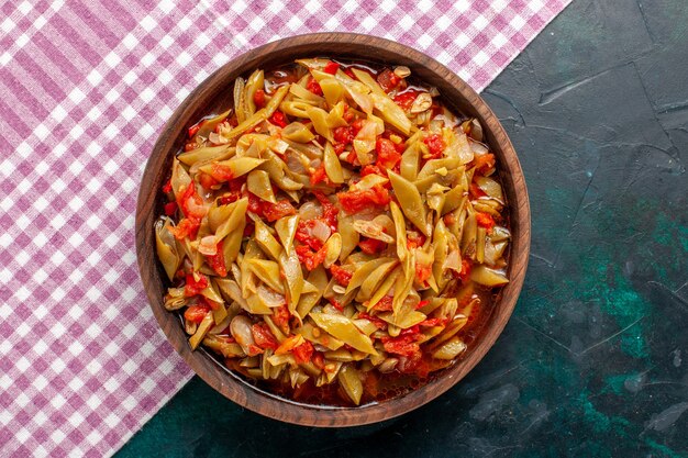 Vue de dessus repas de légumes en tranches délicieux repas à l'intérieur de pot brun sur fond bleu