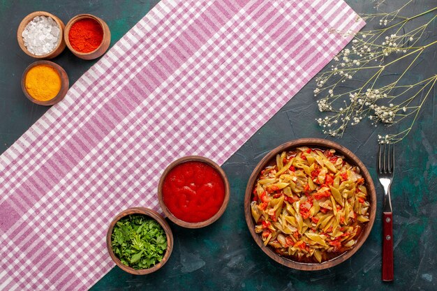 Vue de dessus repas de légumes en tranches avec différents assaisonnements sur le fond bleu