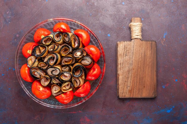 Vue de dessus repas de légumes en tranches et tomates roulées aux aubergines sur le fond sombre