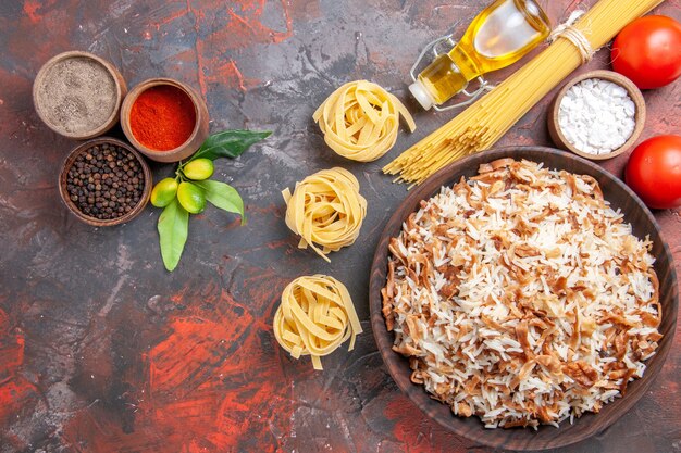 Vue de dessus riz cuit avec assaisonnements sur plat de nourriture de surface sombre repas sombre