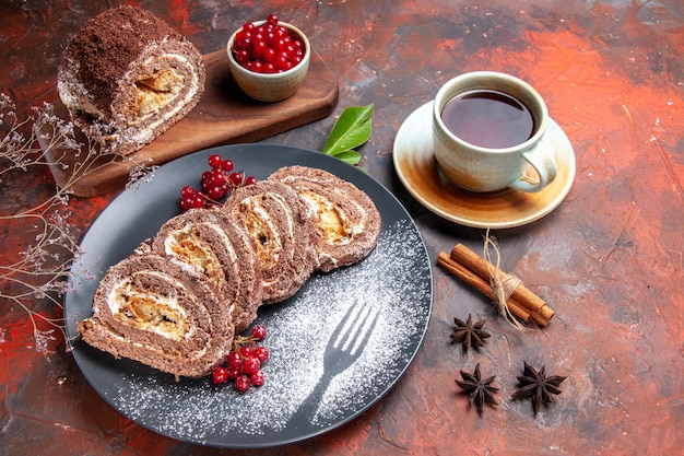 Photo gratuite vue de dessus des rouleaux de biscuits avec une tasse de thé sur une surface sombre