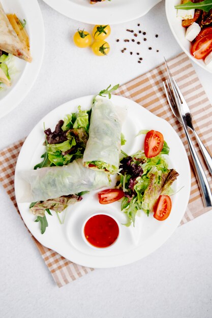 Vue de dessus des rouleaux de chou avec des légumes et de la sauce sur la tablejpg