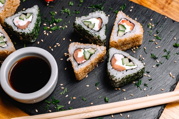 Photo gratuite vue de dessus rouleaux de sushi au saumon avec sauce soja