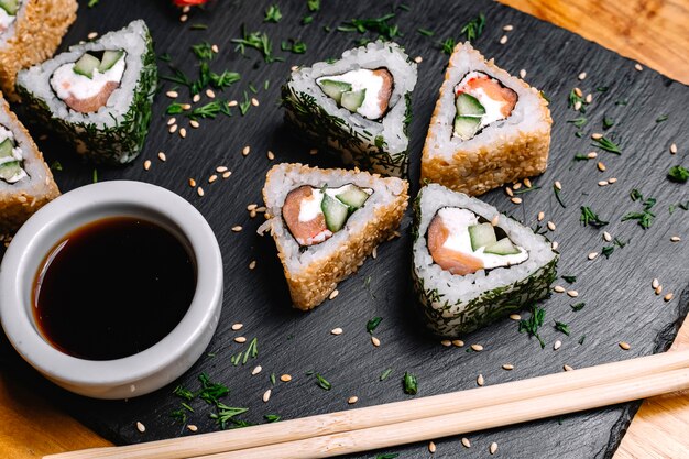 Vue de dessus rouleaux de sushi au saumon avec sauce soja