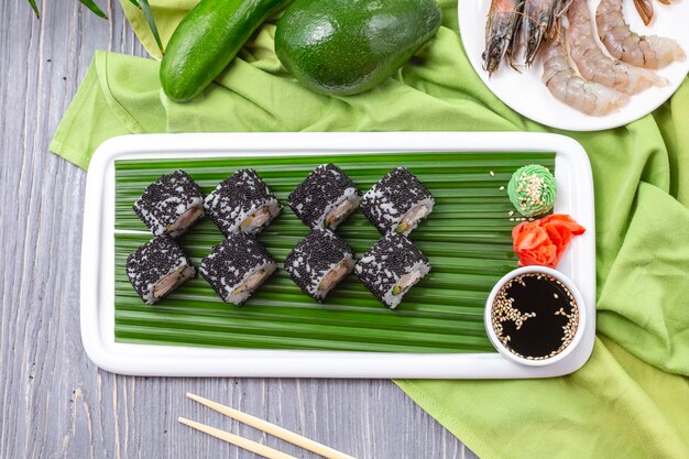 Vue de dessus rouleaux de sushi aux crevettes avec wasabi au gingembre et sauce soja sur une plaque