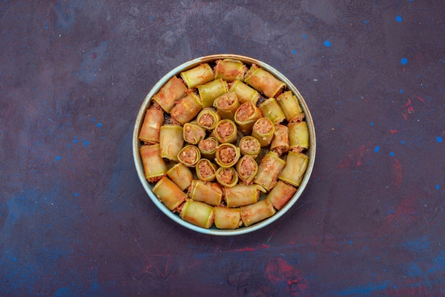 Vue de dessus des rouleaux de viande roulés avec des légumes à l'intérieur de la casserole sur le fond sombre de la viande dîner alimentaire repas légume