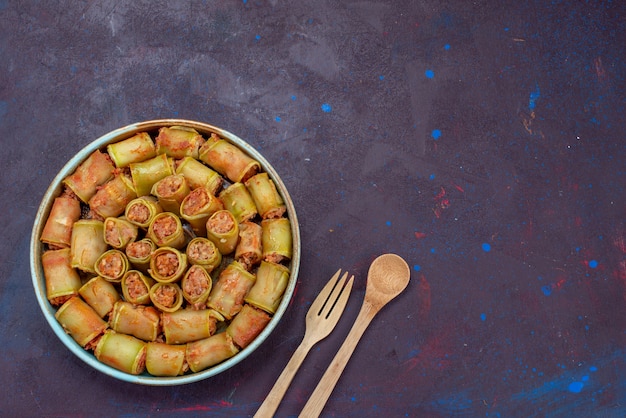 Vue de dessus des rouleaux de viande roulés avec des légumes à l'intérieur de la casserole sur le fond sombre de la viande dîner alimentaire repas de légumes