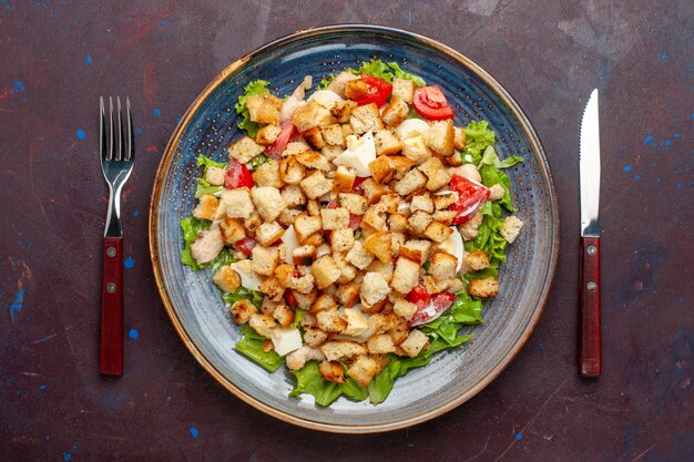 Vue de dessus salade césar avec des légumes en tranches et des biscottes sur le mur sombre salade de légumes repas déjeuner repas biscotte goût