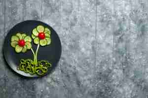 Photo gratuite vue de dessus salade conçue de fleurs de concombres frais sur bureau gris