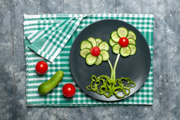 Vue de dessus salade conçue de fleurs de concombres frais sur espace gris