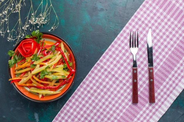 Vue de dessus salade épicée de couleur poivrons en tranches sur le bureau bleu foncé