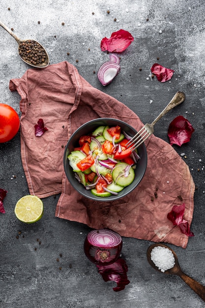 Vue de dessus salade fraîche dans un bol sombre sur un chiffon