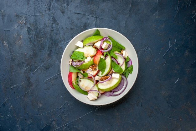 Vue de dessus de la salade fraîche hachée dans un bol fond bleu foncé