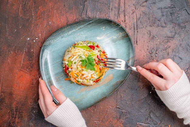 Vue de dessus de la salade de légumes frais à l'intérieur de la plaque sur une table sombre