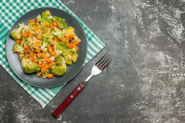 Vue de dessus de la salade de légumes frais et sains sur une serviette dépouillé vert sur fond gris