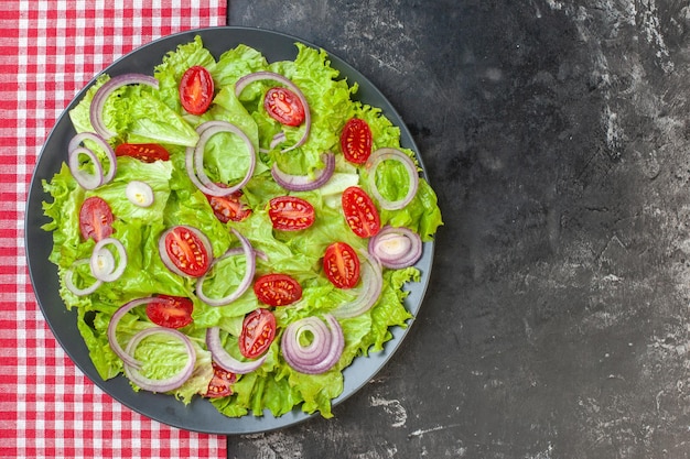 Vue de dessus salade de légumes frais avec salade verte oignons et tomates sur fond gris nourriture mûre santé couleur salade repas photo régime