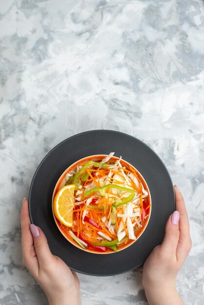 Vue de dessus de la salade de légumes frais sur une surface blanche