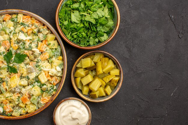 Vue de dessus de la salade de légumes mayonnaise sur une surface sombre