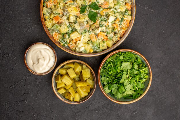 Vue de dessus de la salade de légumes mayonnaise sur une surface sombre